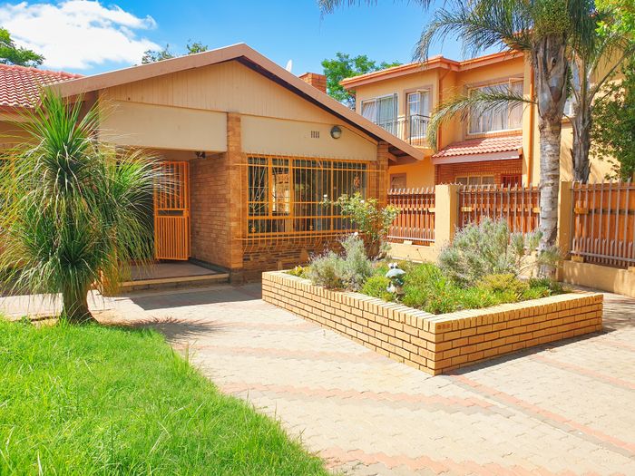 A neat suburban home garden with a lawn and patio